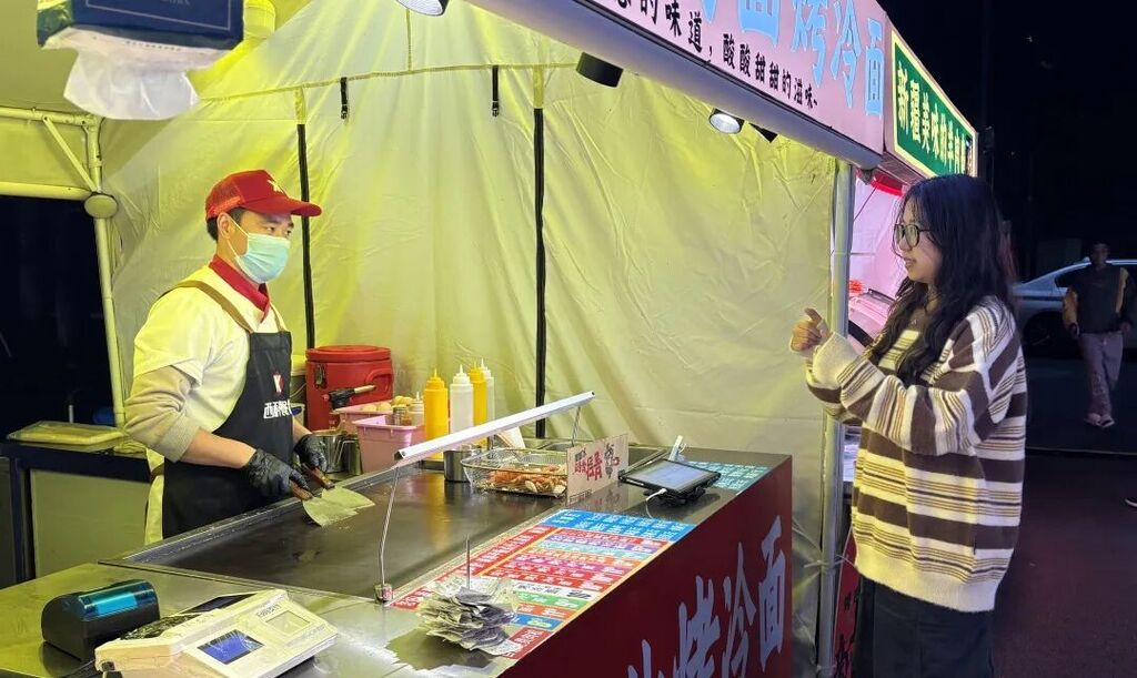 冉诗杨用手语与听障人士李伟沟通。受访单位供图